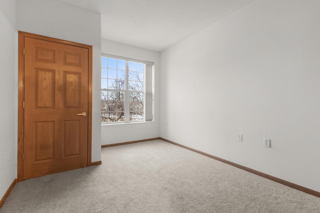 carpeted empty room with a textured ceiling