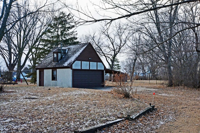 exterior space featuring a garage and an outbuilding