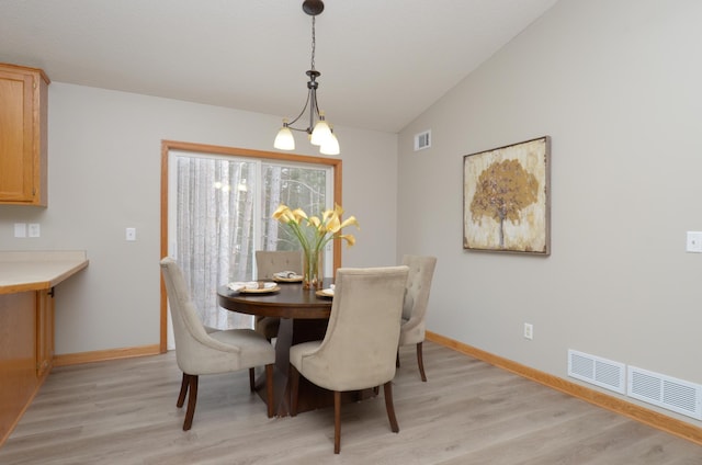 dining space featuring light hardwood / wood-style flooring and vaulted ceiling