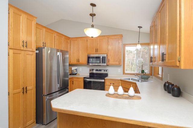 kitchen with sink, vaulted ceiling, appliances with stainless steel finishes, kitchen peninsula, and pendant lighting