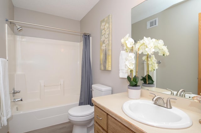 full bathroom featuring hardwood / wood-style floors, vanity, toilet, a textured ceiling, and shower / bath combo with shower curtain