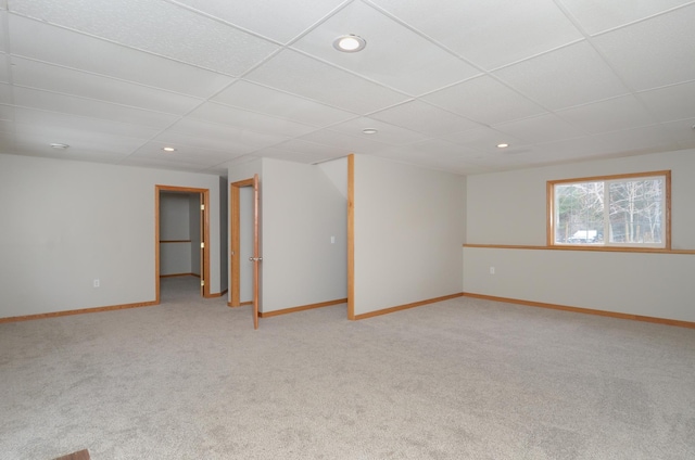 unfurnished room featuring a paneled ceiling and light carpet