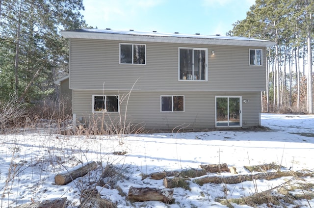 view of snow covered back of property