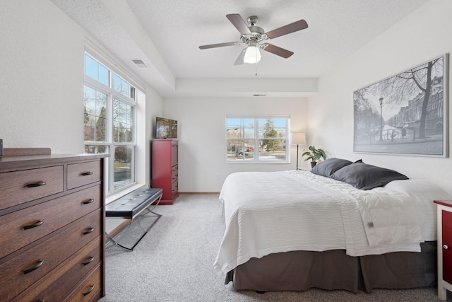 carpeted bedroom with multiple windows, a textured ceiling, and ceiling fan