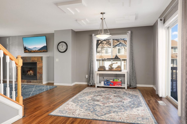 dining area with a tiled fireplace and dark hardwood / wood-style floors