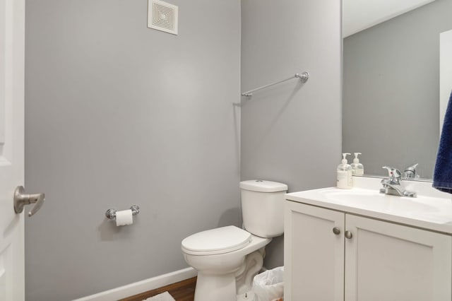 bathroom featuring vanity, wood-type flooring, and toilet