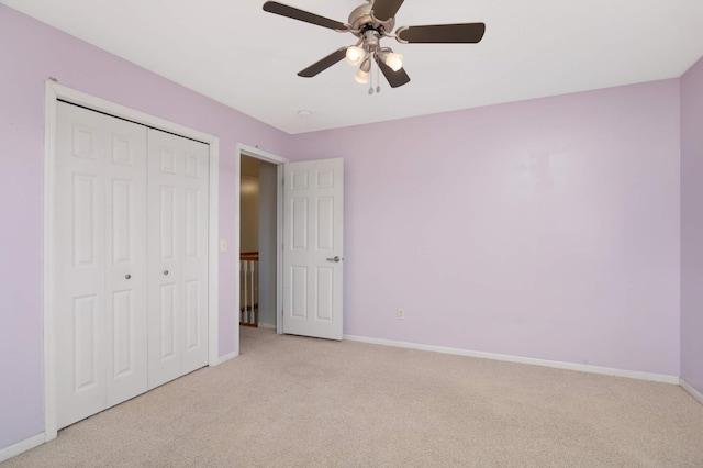 unfurnished bedroom featuring light colored carpet, a closet, and ceiling fan