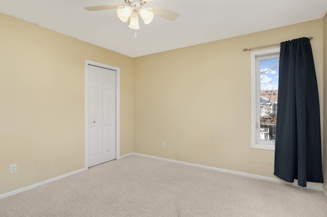 carpeted spare room featuring ceiling fan