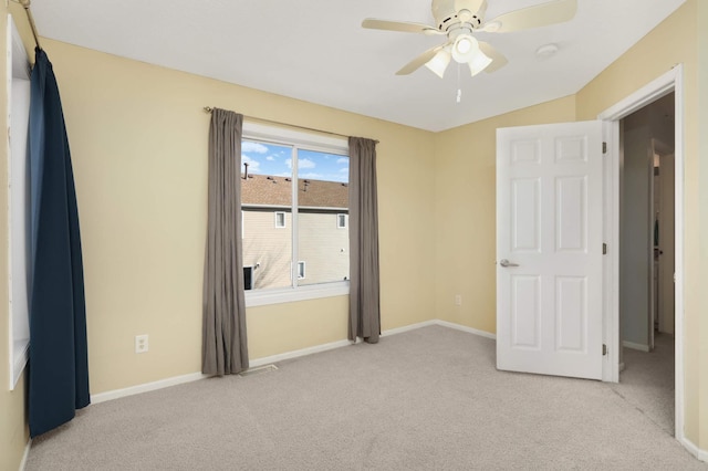 carpeted spare room featuring lofted ceiling and ceiling fan