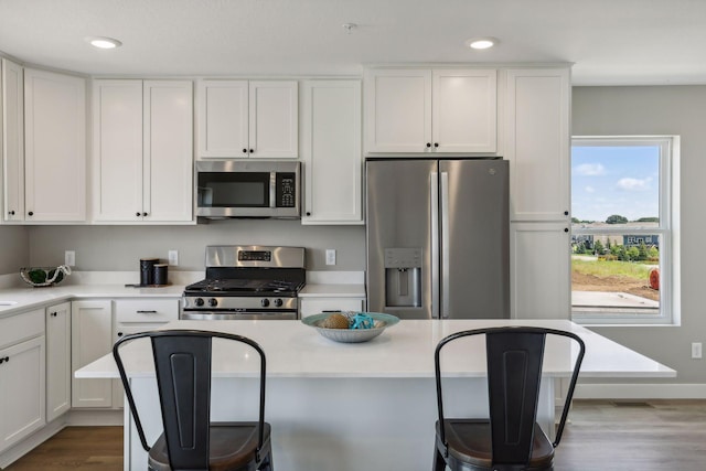 kitchen featuring white cabinetry, appliances with stainless steel finishes, and hardwood / wood-style floors