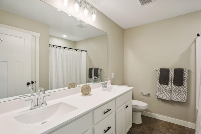 bathroom featuring vanity, tile patterned floors, and toilet