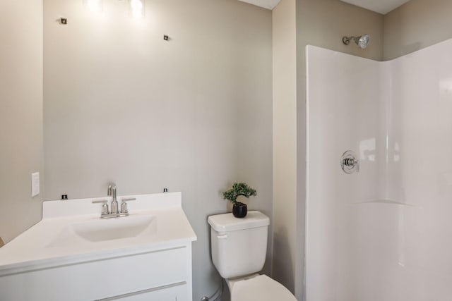 bathroom featuring vanity, a shower, and toilet