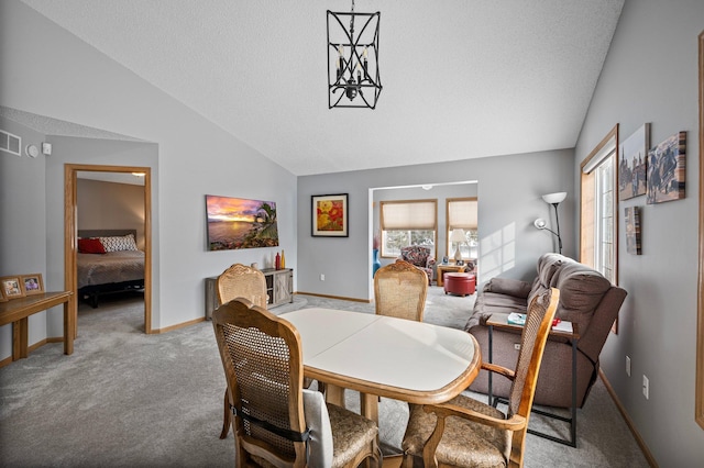 dining space with lofted ceiling, baseboards, carpet floors, and a textured ceiling