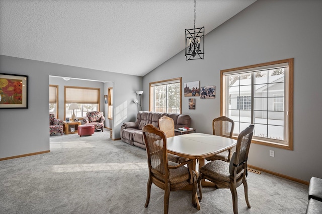 carpeted dining area featuring high vaulted ceiling, baseboards, and a textured ceiling