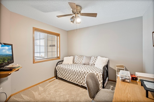 carpeted bedroom featuring a ceiling fan, a textured ceiling, and baseboards