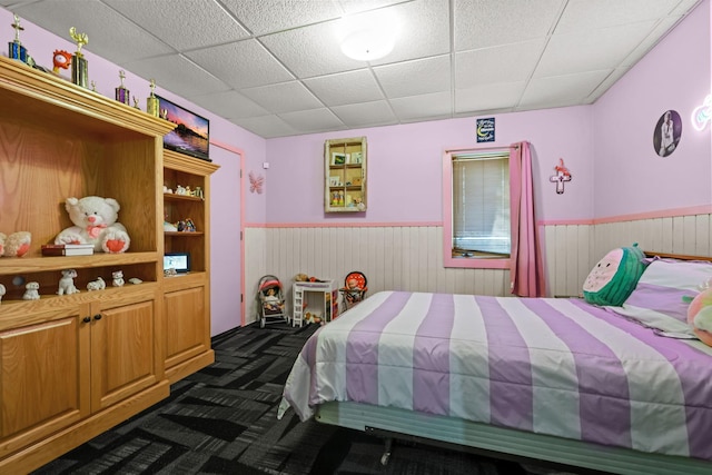 carpeted bedroom featuring a drop ceiling