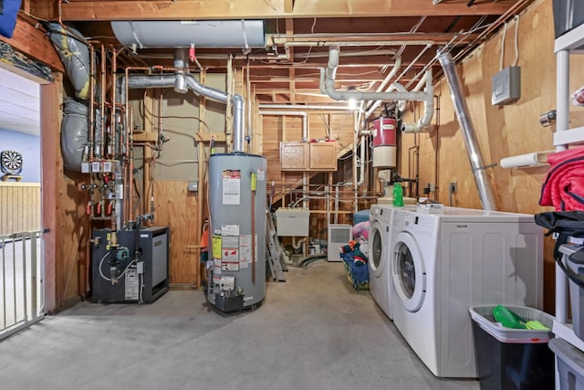 interior space featuring sink, wooden walls, washing machine and dryer, and water heater