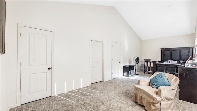 sitting room with high vaulted ceiling and carpet