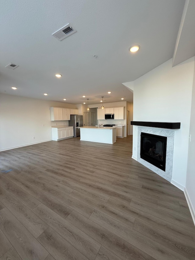 unfurnished living room featuring dark wood-type flooring and sink