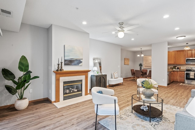 living room with ceiling fan and light hardwood / wood-style flooring