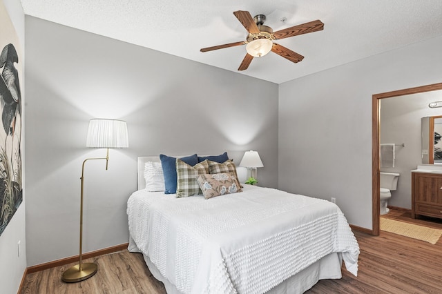 bedroom featuring hardwood / wood-style flooring, ensuite bathroom, a textured ceiling, and ceiling fan