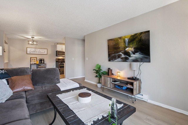 living room featuring light hardwood / wood-style flooring and a textured ceiling