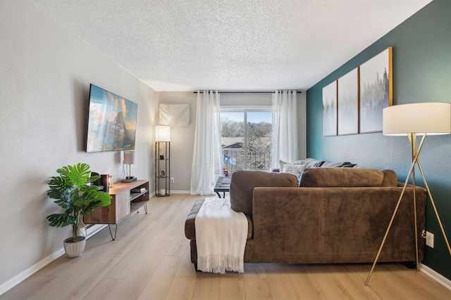 living room with light hardwood / wood-style flooring and a textured ceiling