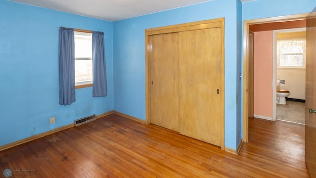 unfurnished bedroom with hardwood / wood-style flooring and a closet