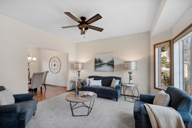 living room with wood-type flooring and ceiling fan with notable chandelier