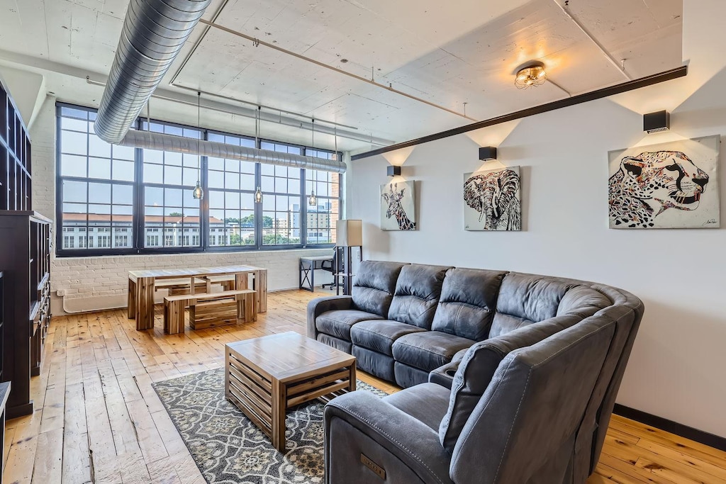 living room with hardwood / wood-style flooring and brick wall