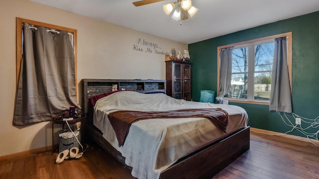 bedroom with dark hardwood / wood-style floors and ceiling fan