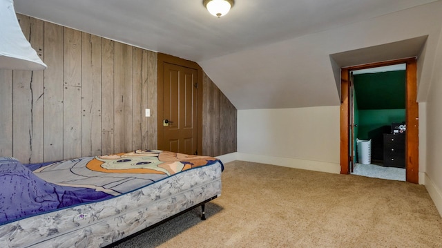 bedroom featuring vaulted ceiling, carpet floors, and wood walls