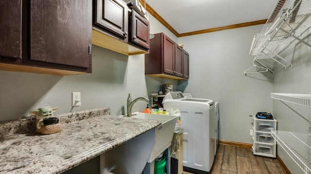 laundry room with cabinets, washing machine and clothes dryer, crown molding, and dark wood-type flooring