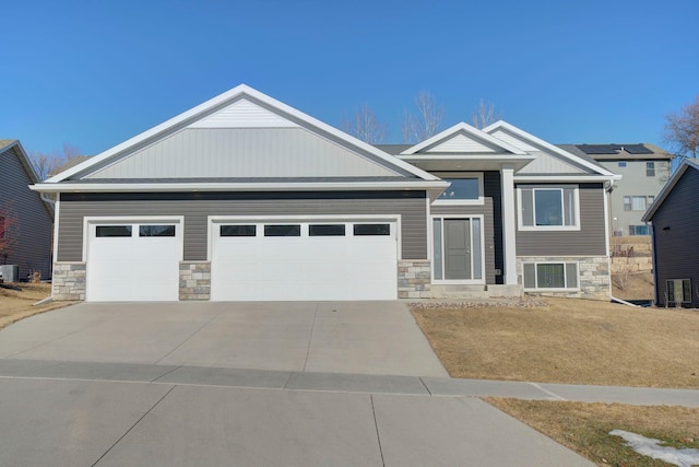 view of front of house featuring a garage, central AC unit, and a front lawn