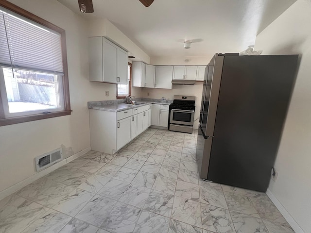 kitchen with ceiling fan, appliances with stainless steel finishes, sink, and white cabinets