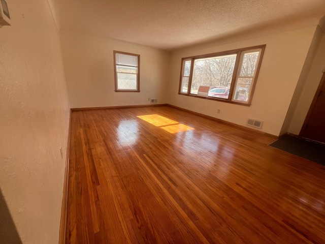 spare room featuring a textured ceiling and light wood-type flooring