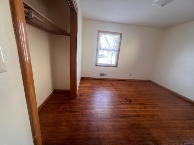 unfurnished bedroom featuring dark hardwood / wood-style flooring and a closet