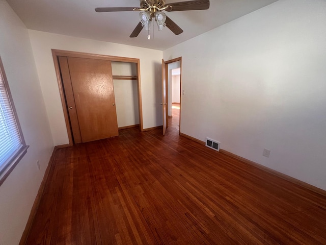 unfurnished bedroom featuring a closet, dark hardwood / wood-style floors, and ceiling fan