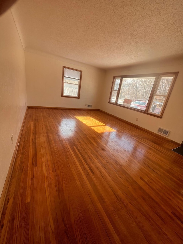 bonus room featuring hardwood / wood-style floors and a textured ceiling