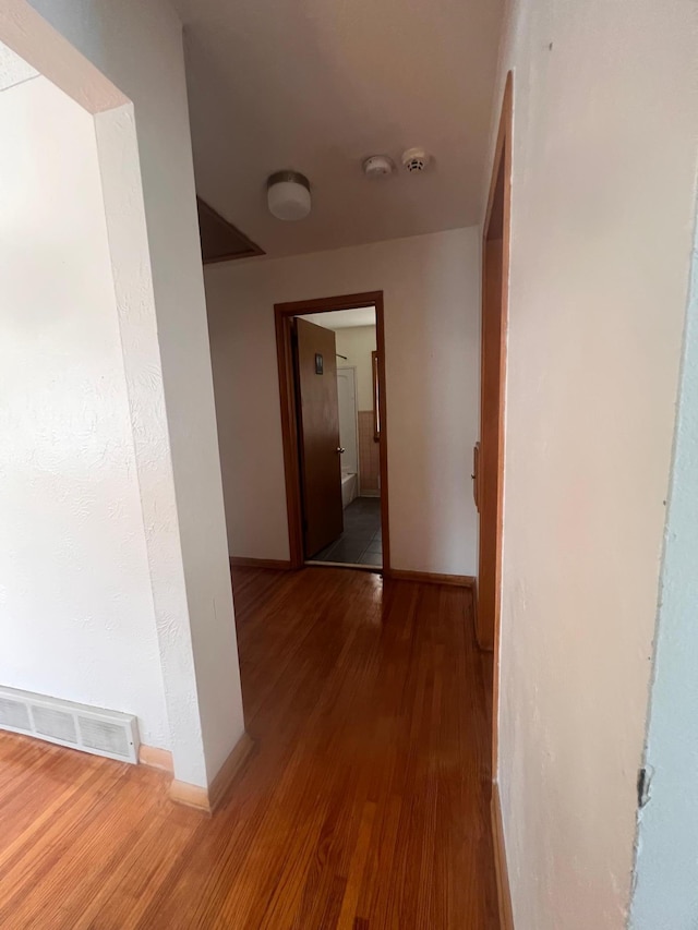 corridor with hardwood / wood-style flooring