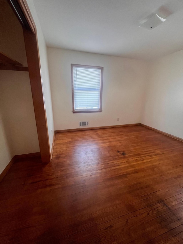 unfurnished bedroom featuring a closet and dark hardwood / wood-style floors