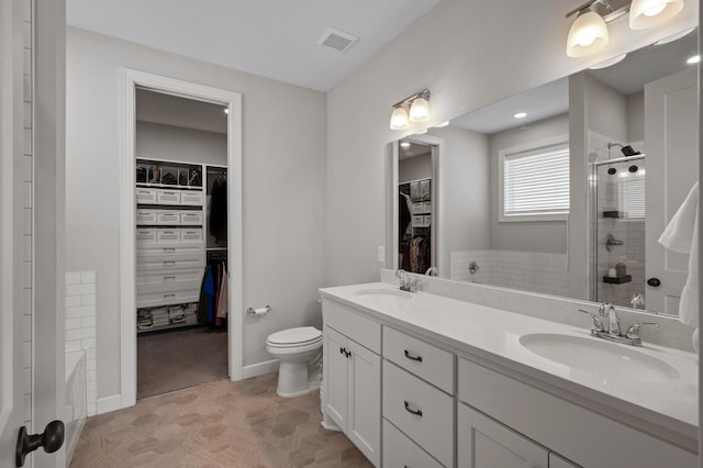 bathroom with vanity, toilet, and a tile shower