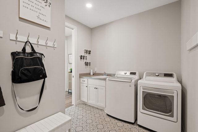 washroom featuring cabinets, separate washer and dryer, and sink