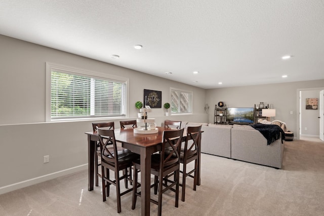 carpeted dining space with a textured ceiling