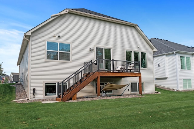 rear view of house with a wooden deck and a yard