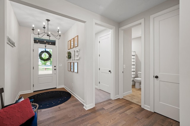 foyer entrance featuring an inviting chandelier and wood-type flooring