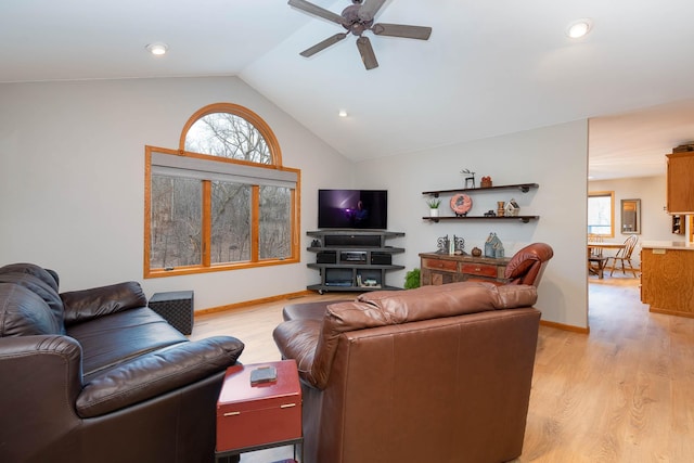 living room with plenty of natural light, vaulted ceiling, and light hardwood / wood-style flooring