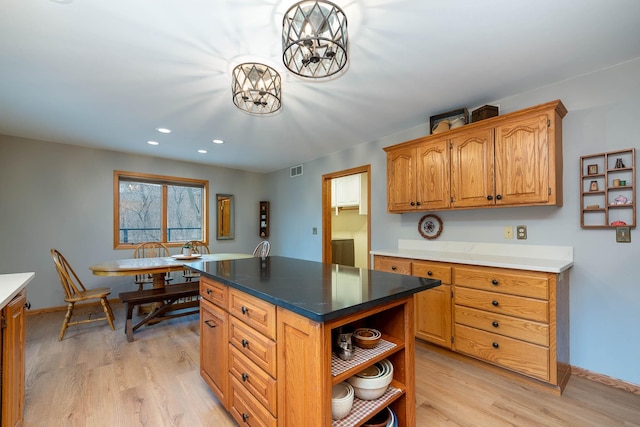 kitchen featuring a notable chandelier, light hardwood / wood-style floors, and a kitchen island