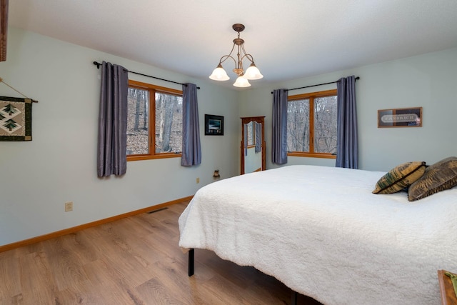 bedroom featuring light hardwood / wood-style flooring and a chandelier