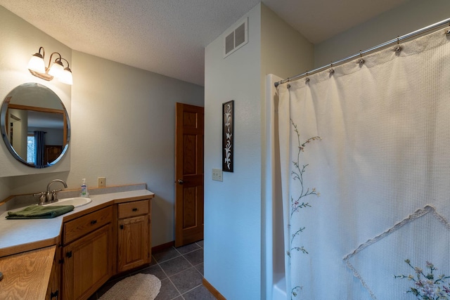 bathroom featuring tile patterned floors, curtained shower, a textured ceiling, and vanity